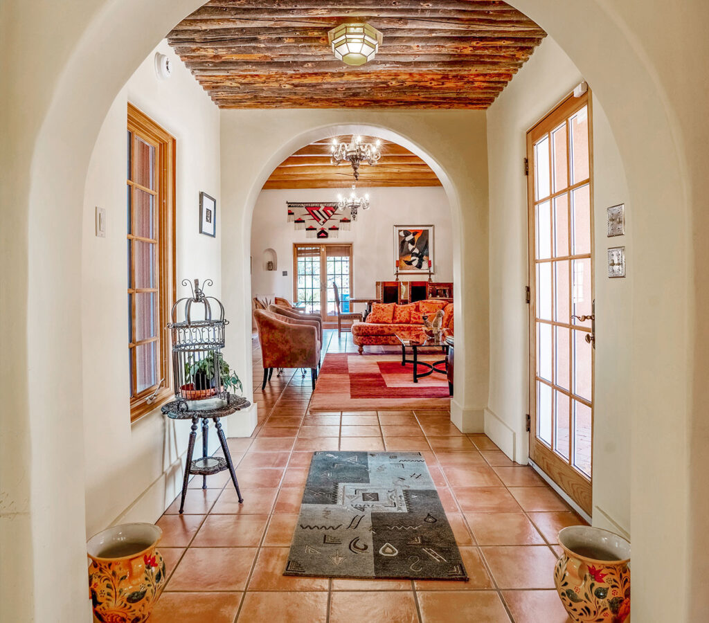 Interior of home with arches, vigas, and tile floors.